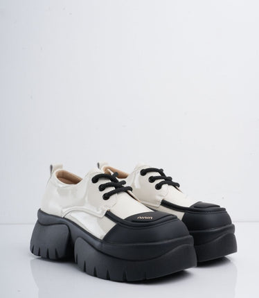 Zapatos blancos en charol con suela y cordones negros