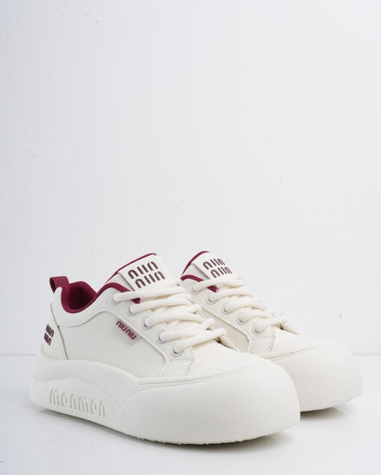 Tenis blancos con líneas y detalles vinotinto