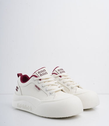 Tenis blancos con líneas y detalles vinotinto