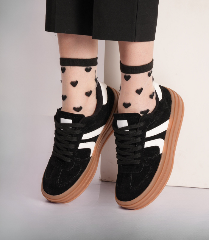 Tenis negros con líneas blancas y cordones