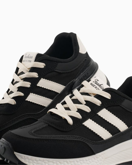 tenis negros con líneas blancas