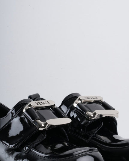 Zapatos negros de charol con herraje y correa plateada