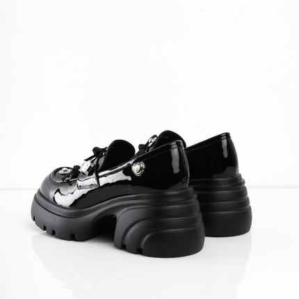 Zapatos negros de charol con múltiples apliques