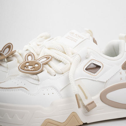 Tenis blancos con accesorios y detalles café