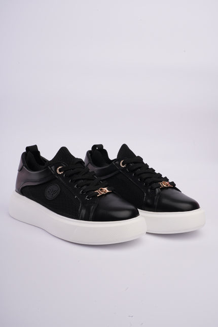 Tenis casuales negros con detalles metálicos y diseño en malla