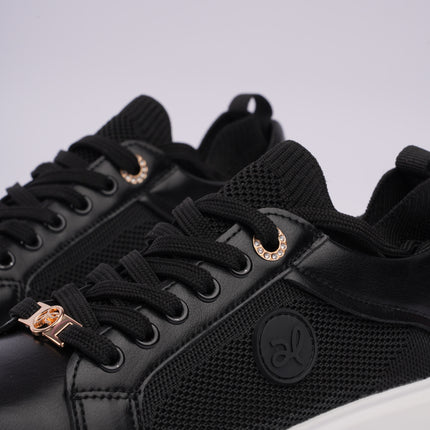 Tenis casuales negros con detalles metálicos y diseño en malla