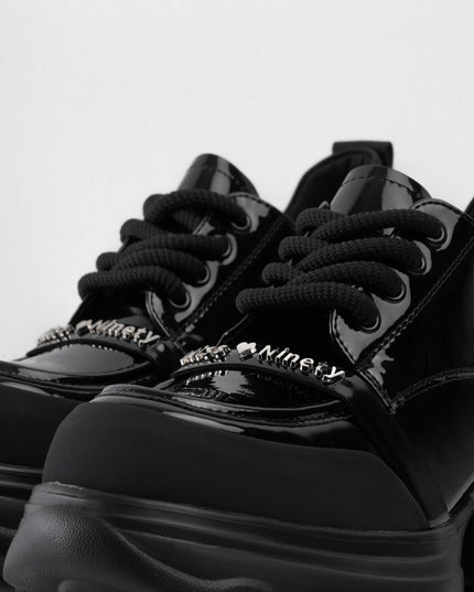 Zapatos negros de charol con cordones y aplique