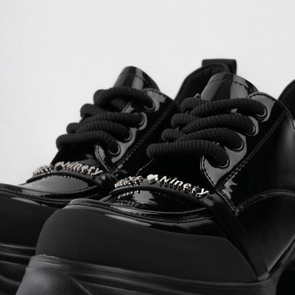 Zapatos negros de charol con cordones y aplique